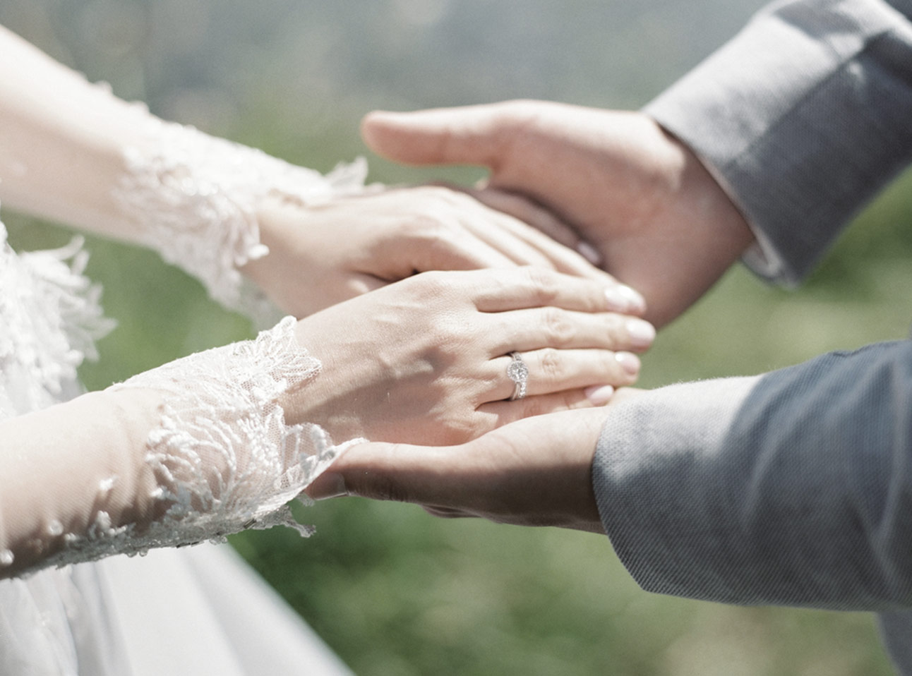 Two hands, one wearing an engagement ring stock photo - OFFSET